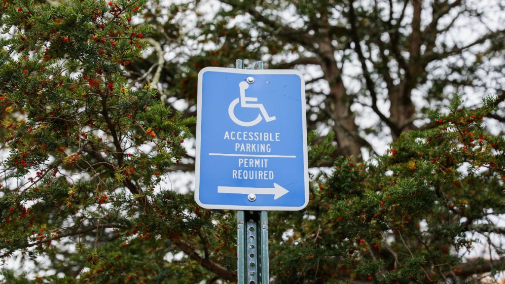 ADA compliant parking lot featuring a sign directing to handicap accessible parking spaces