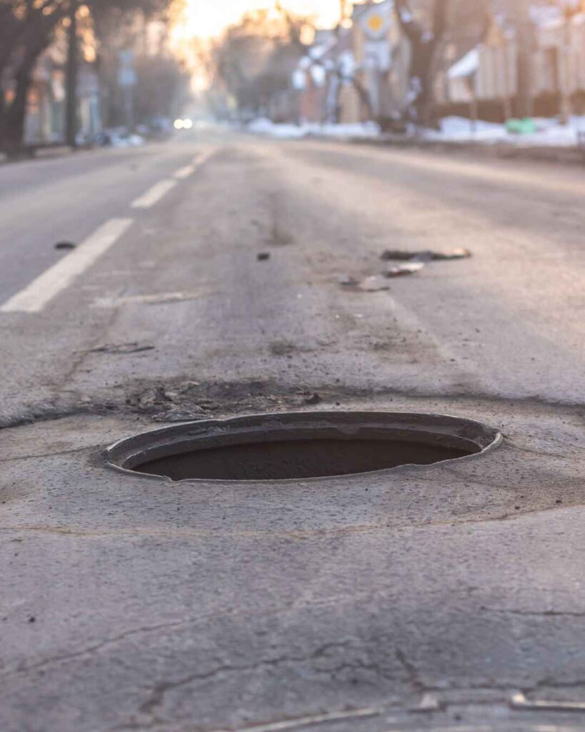 road in poor condition with signs you need asphalt repair in cincinnati
