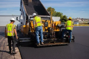 paving crew performing an asphalt paving project in a commercial parking lot