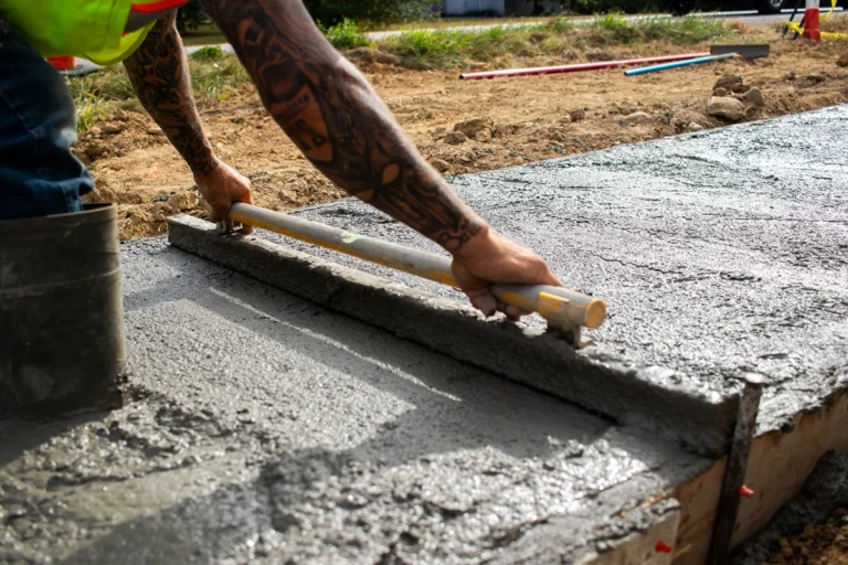 worker laying concrete for a concrete curb
