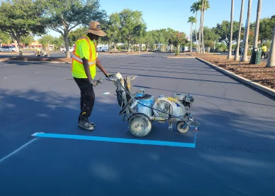 worker adding pavement striping to bass pro parking lot