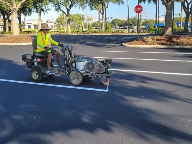 Employee Marking Pavement in Parking Lot