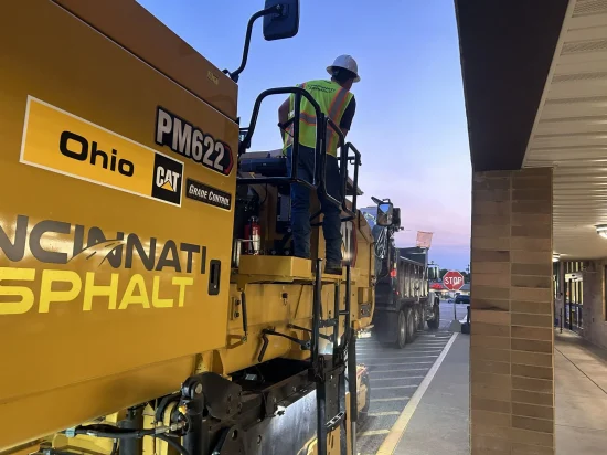 paving contractor employee on a heavy machine that has cincinnati asphalt on the side