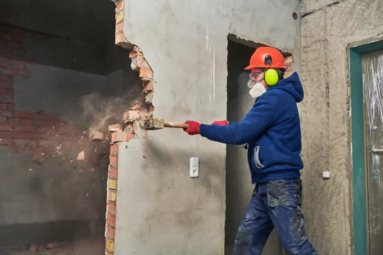 man using a hammer to preform demolition on a building in cincinnati